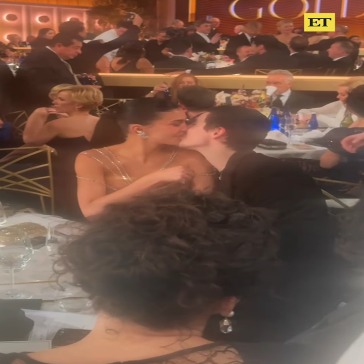 Kylie and Timmy kissing at an elegant event, surrounded by others seated at tables