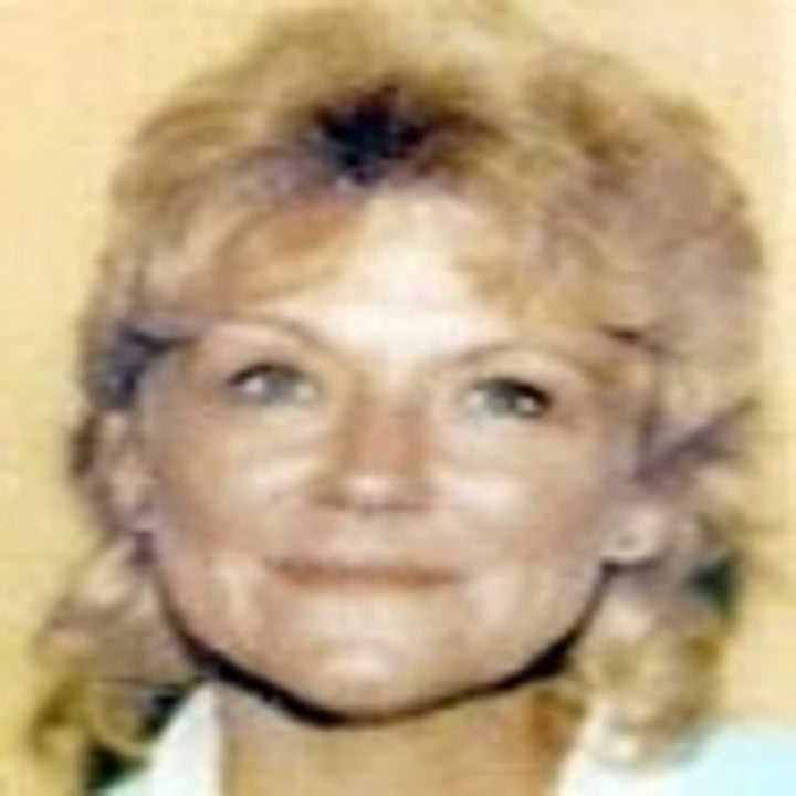 A woman with light hair smiling at the camera in a close-up portrait